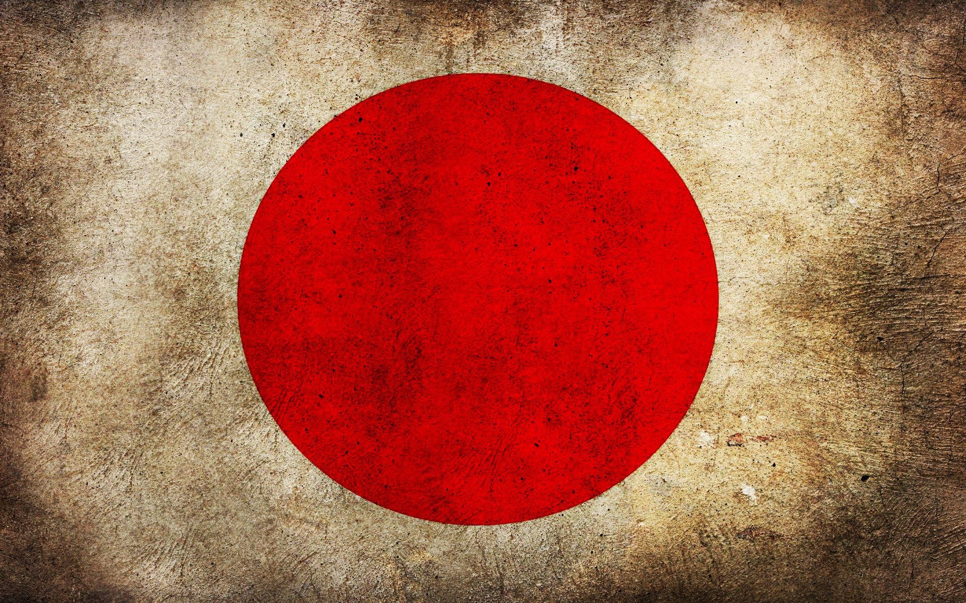 日本國旗塵土風攝影 壁紙 — 一面風化的日本國旗，在質感米色背景中央有一個醒目的紅色圓圈。