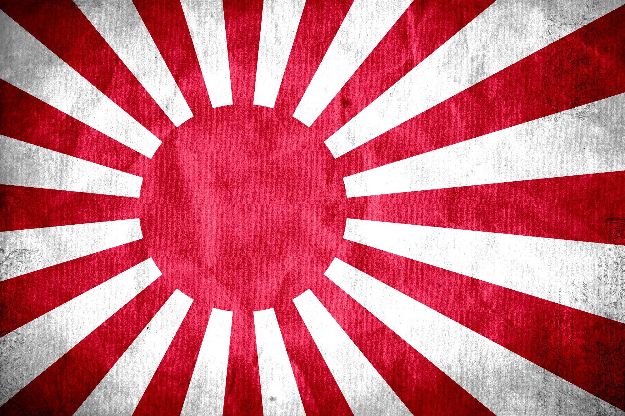 日本國旗的薄霧日出 壁紙 — 一面經風化的日本旭日旗，在質感布料上帶有鮮明的紅白光芒。