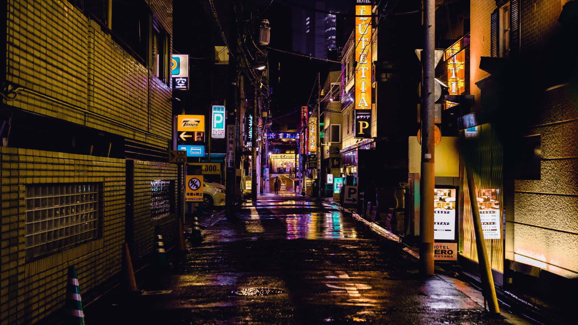 Dark Alleyway 桌布 壁紙 — 日本城市夜晚一條被雨水浸濕、霓虹燈照亮的小巷，在潮濕的路面上反射出閃爍的招牌。
