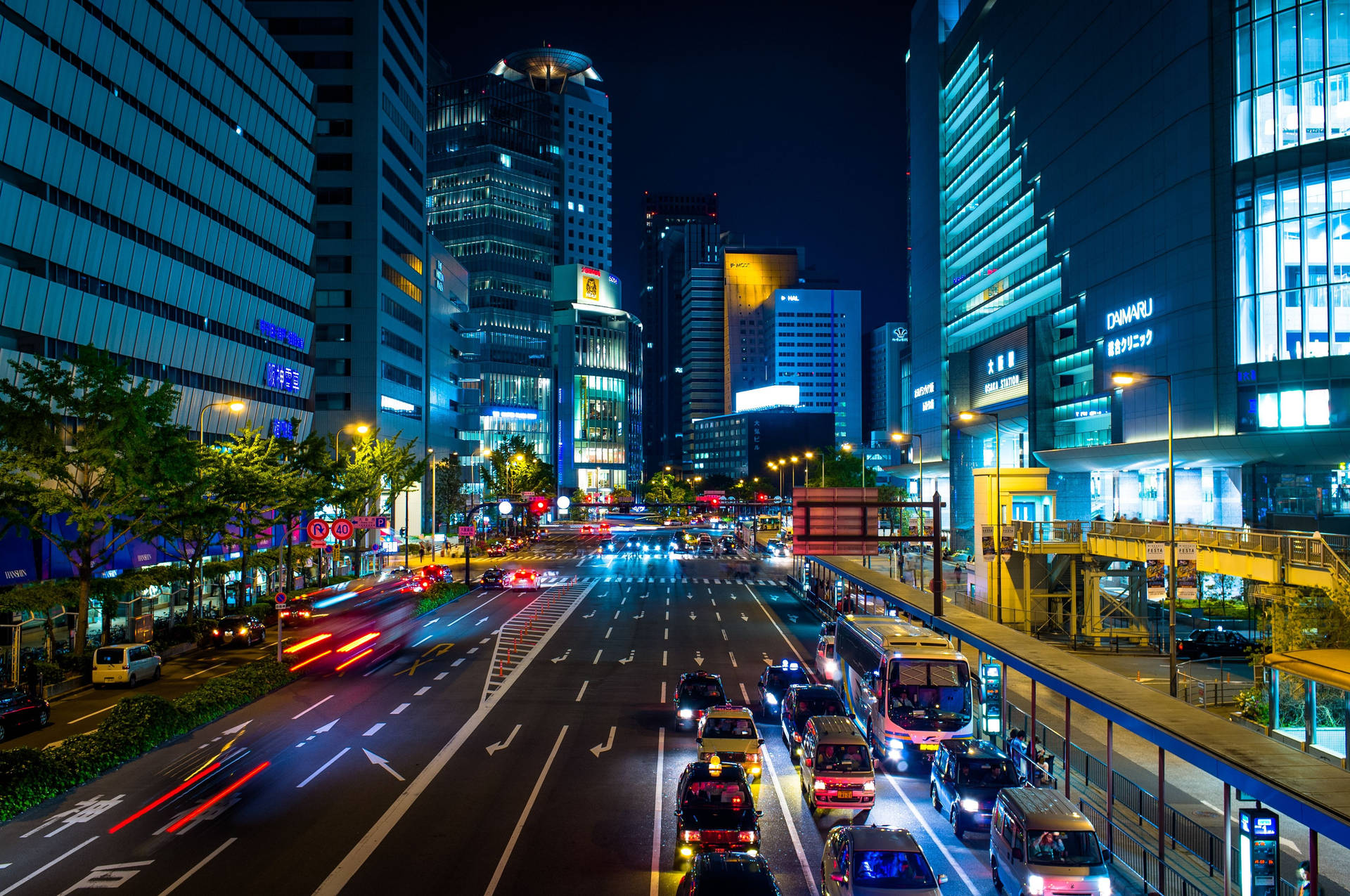 日本壯麗的城市景觀 壁紙 — 充滿活力的夜間城市景觀，有發光的摩天大樓和繁忙城市街道上流動的車燈。