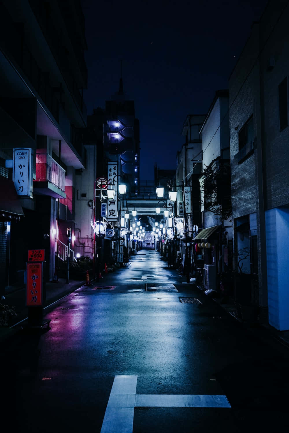Night Street 桌布 壁紙 — 日本夜晚一條狹窄潮濕的小巷，被發光的霓虹燈招牌和路燈照亮，倒影映在路面上。