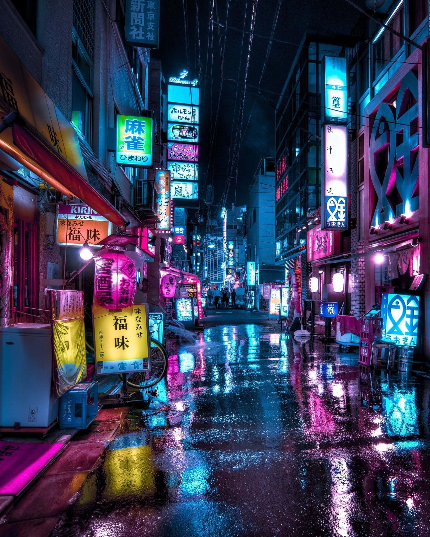 日本市中心的霓虹燈舞 壁紙 — 東京夜晚一條被雨水浸濕、霓虹燈照亮的後巷，在濕漉漉的路面上反射出鮮豔的粉紅色、藍色和黃色招牌。