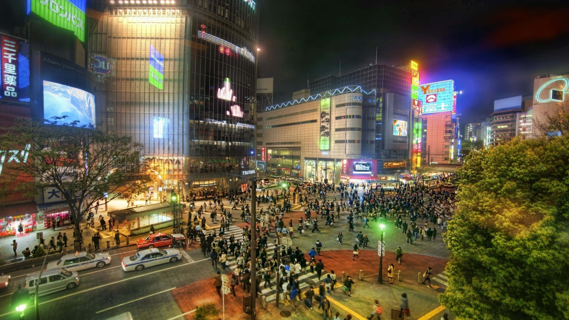 夜晚的東京街道擠滿了人，高樓上明亮的霓虹燈招牌閃爍。