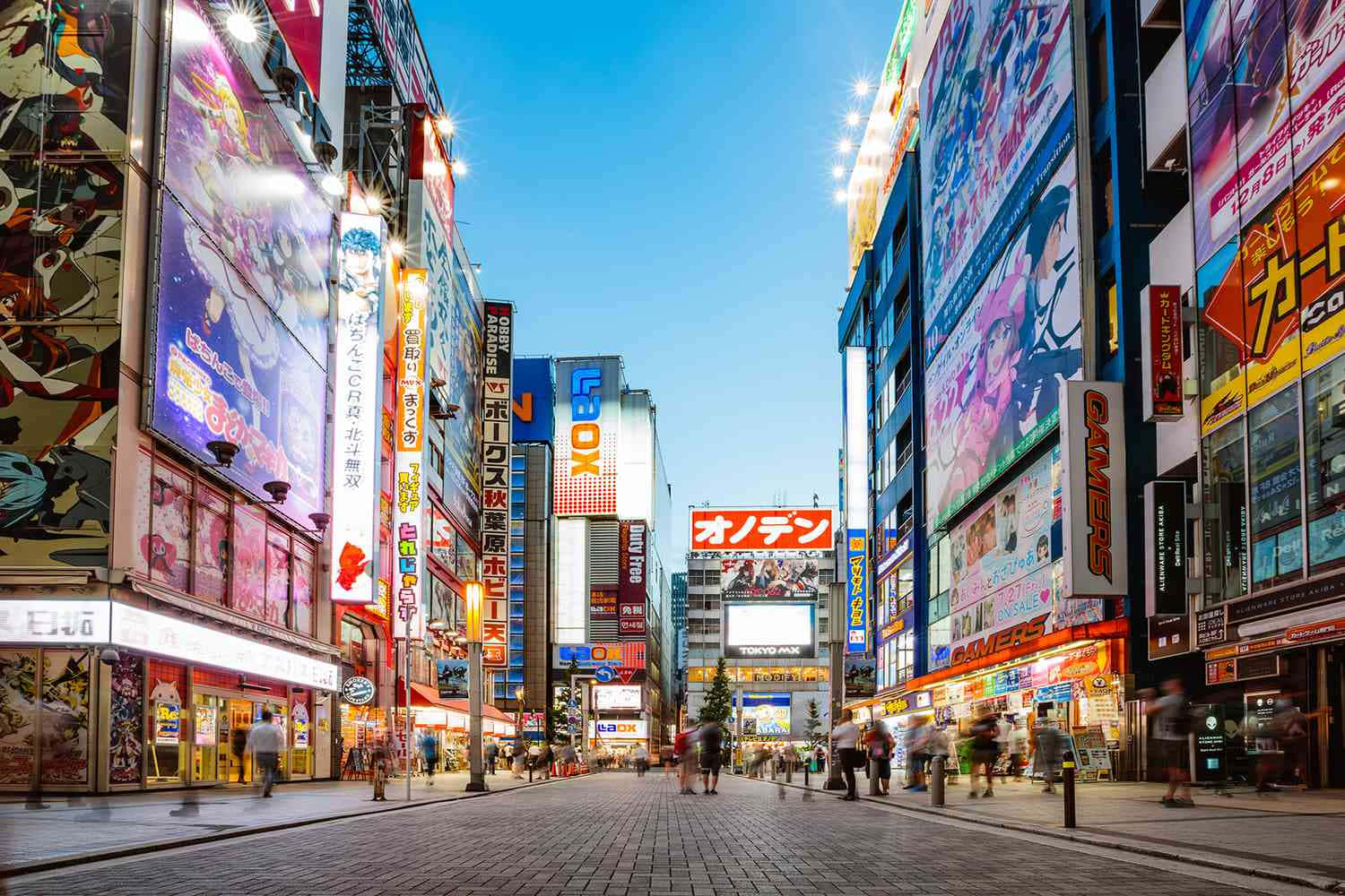 黃昏時分熙攘的東京街頭，發光的動畫廣告牌和行人。