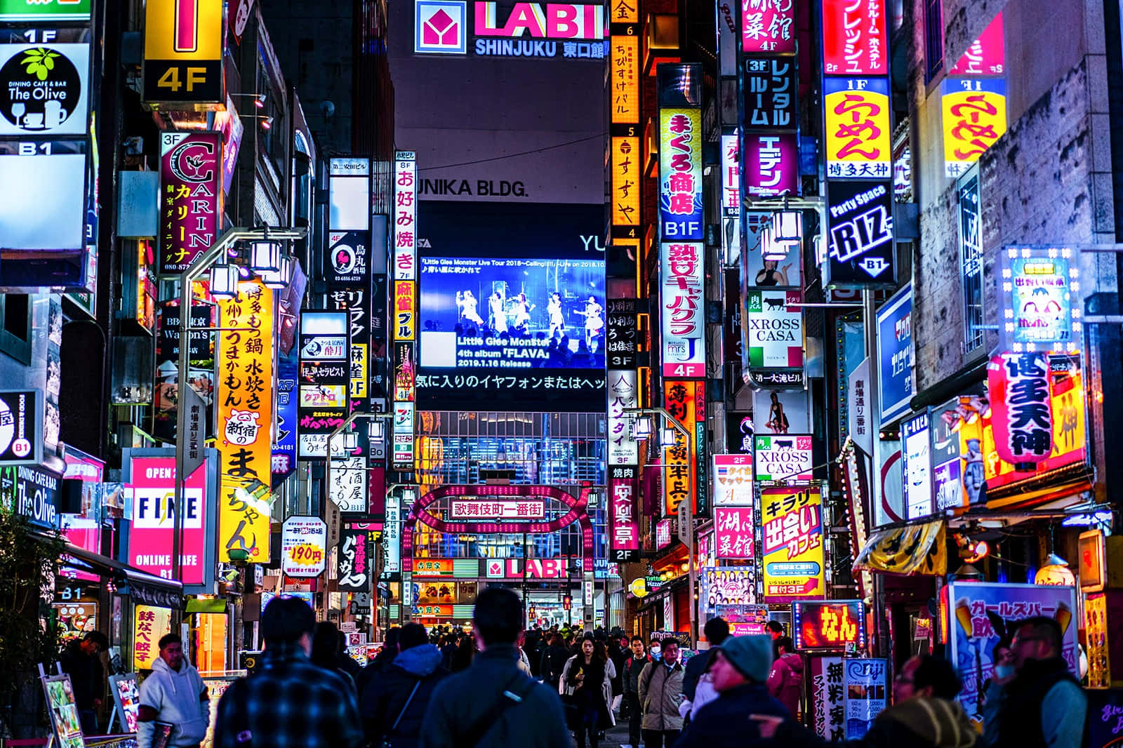 人群在發光的霓虹燈下行走於繁忙的東京夜街。