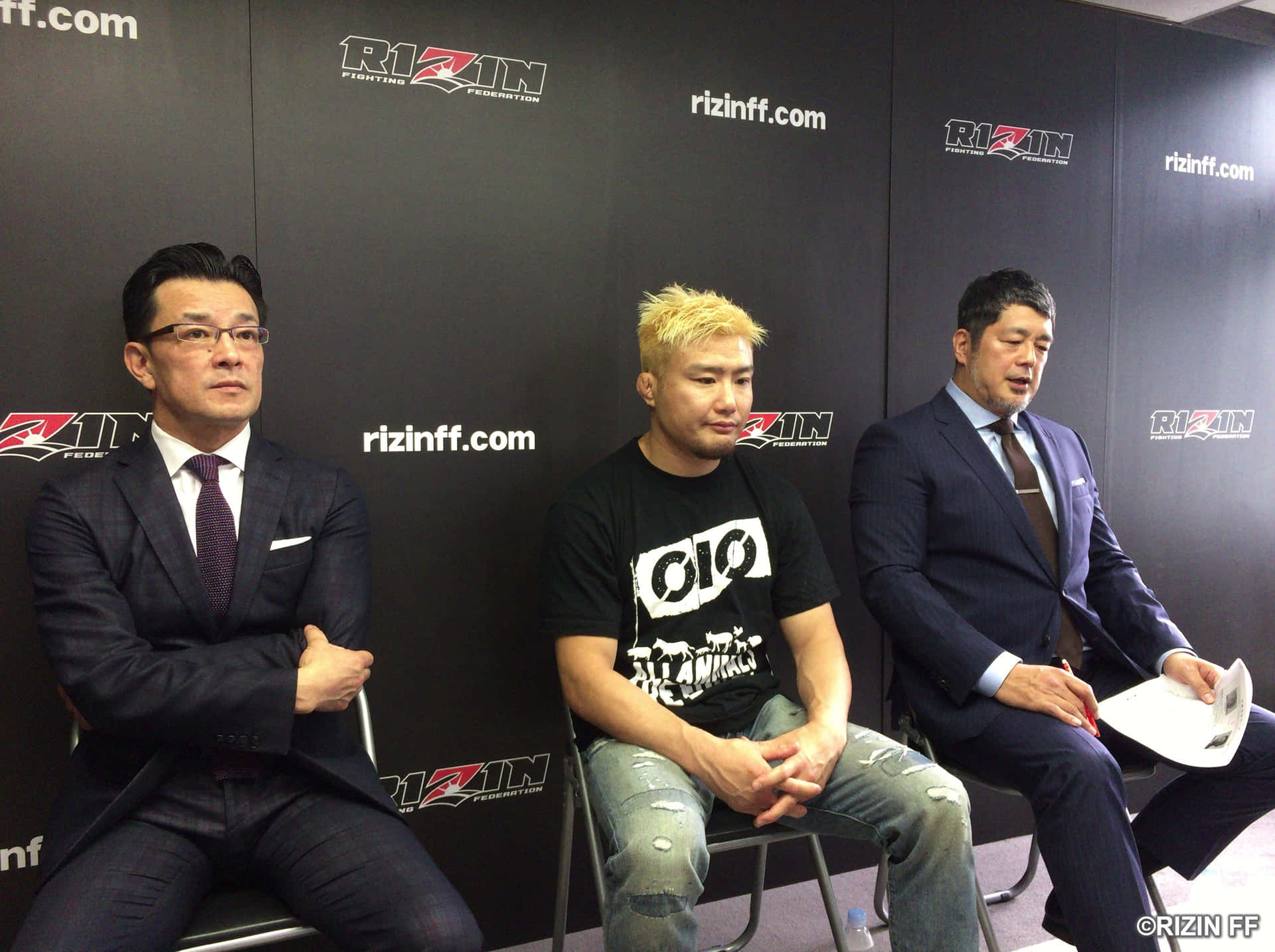 三名男子坐在記者會上，背後有Rizin FF品牌標誌。