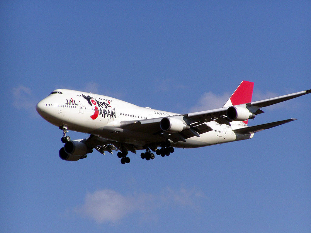 日本航空波音747飛機放下起落架在藍天中降落。