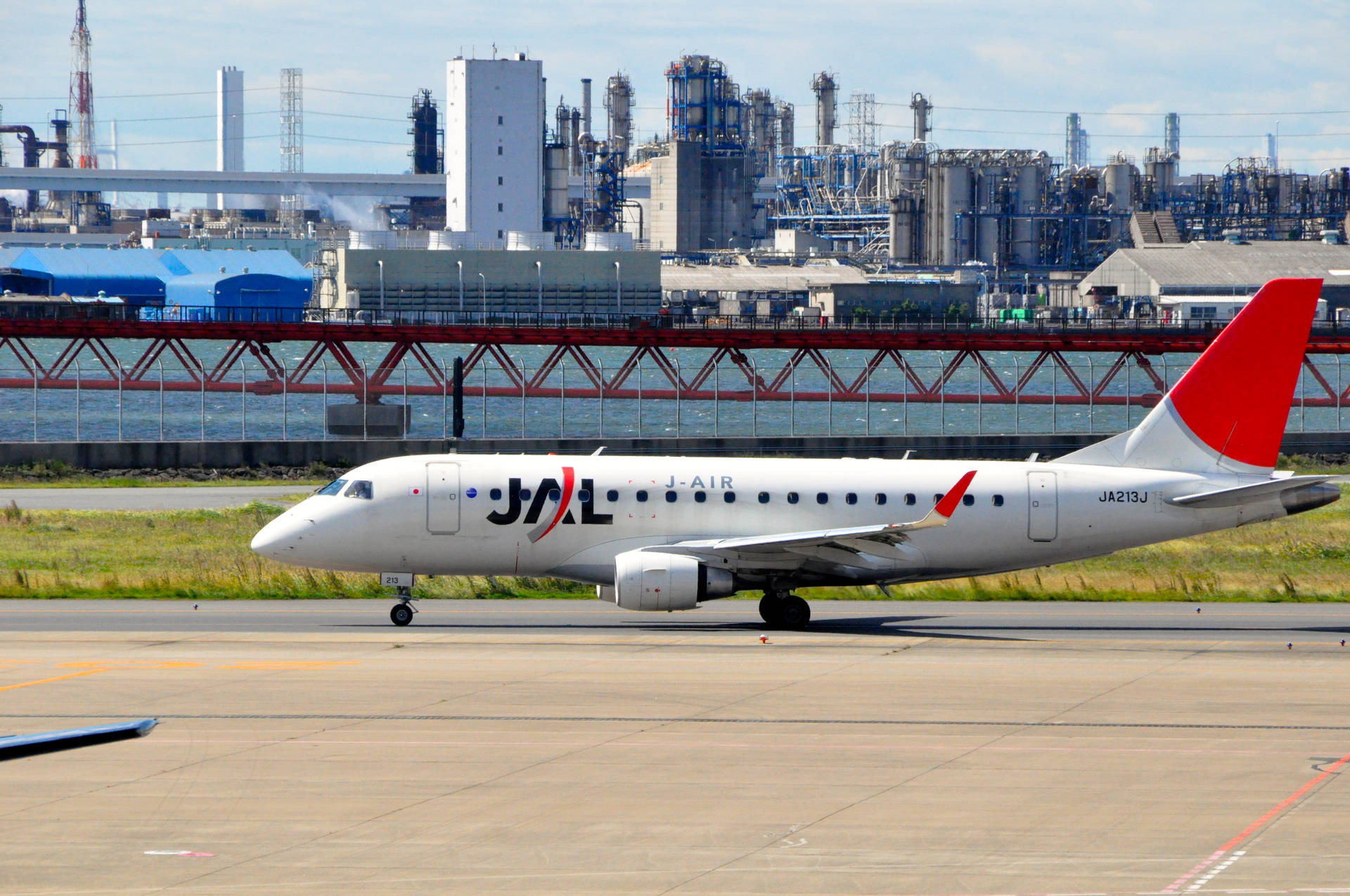 J-AIR飛機在工業區和紅色橋樑附近的跑道上。