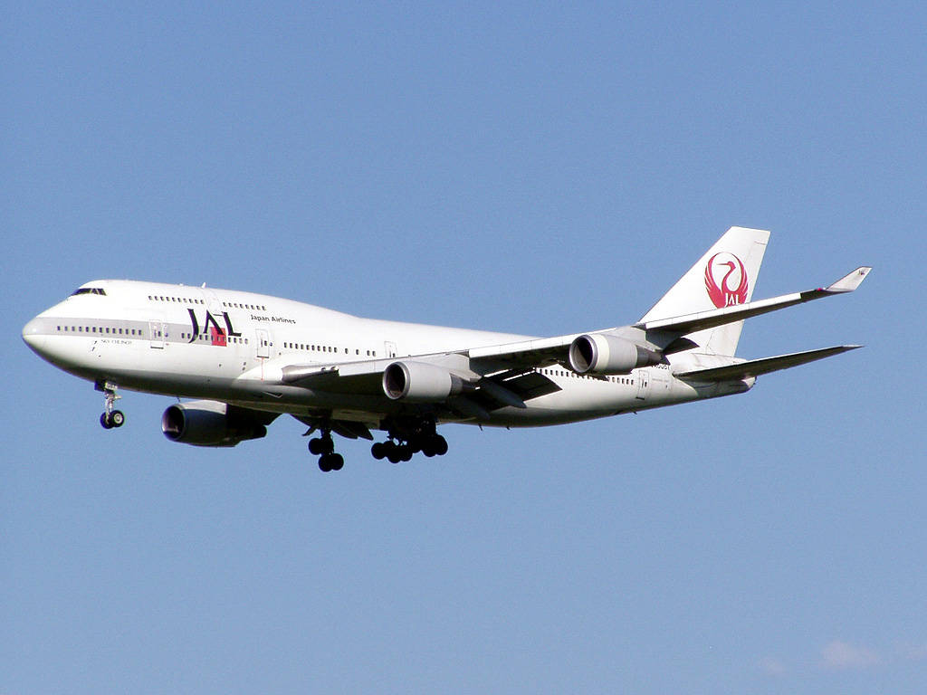 日本航空波音747飛機起落架放下在藍天中降落