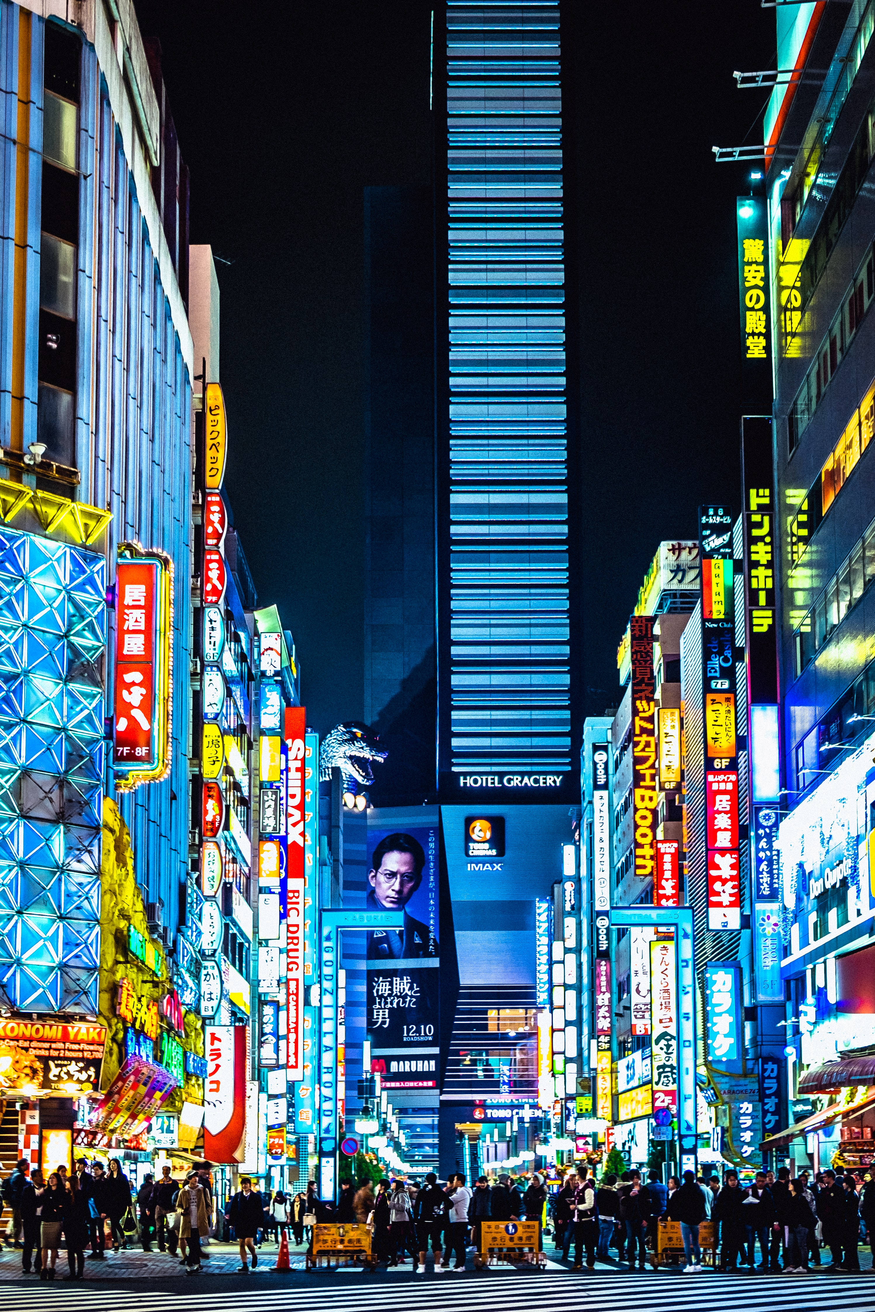 霓虹燈照亮嘅東京夜晚街道，人群同高聳嘅招牌。