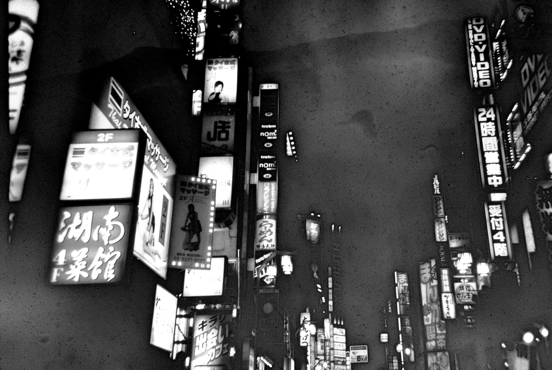 東京霓虹燈街道的夜間垂直黑白照片。