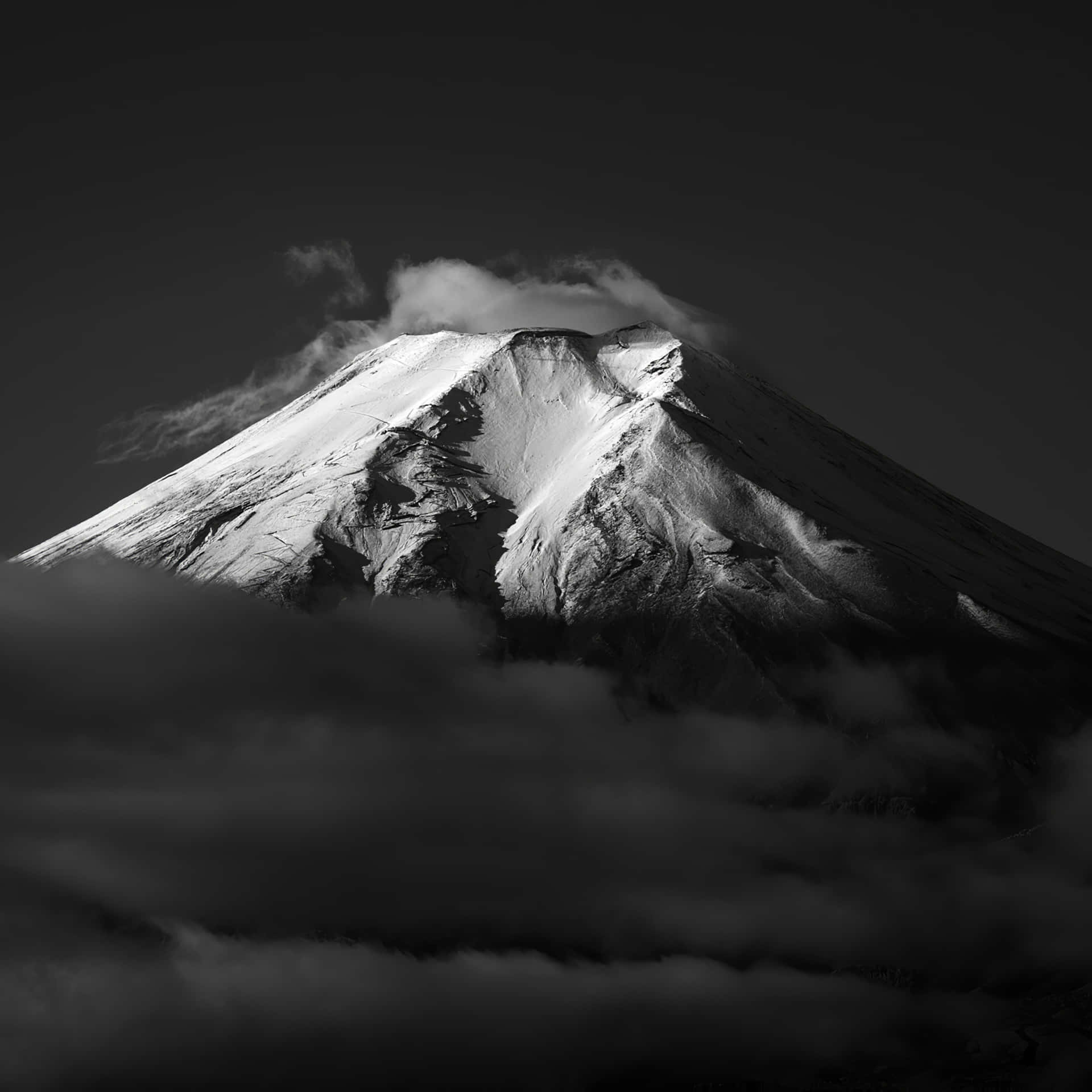 白雪覆蓋的山峰在黑白中聳立於雲層之上