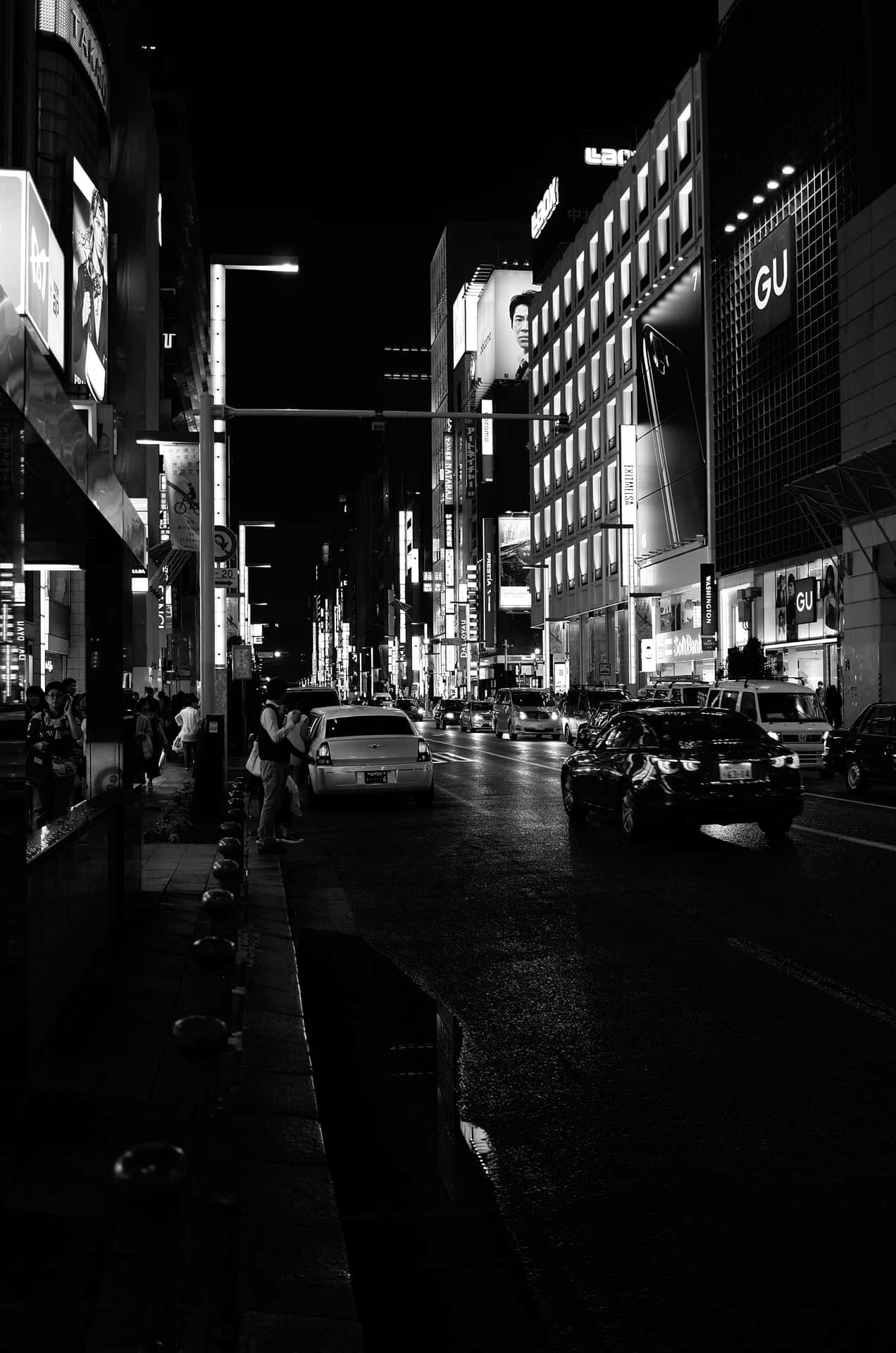 繁華城市的雨夜街道，閃爍的霓虹燈牌和移動的汽車。