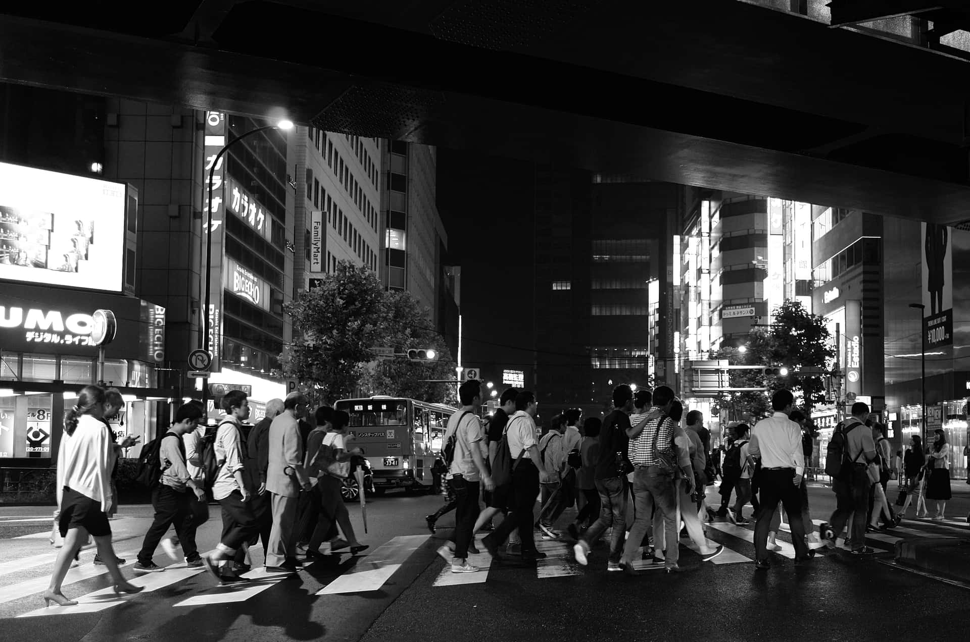 夜晚人群在霓虹燈下穿越繁忙的東京街道。
