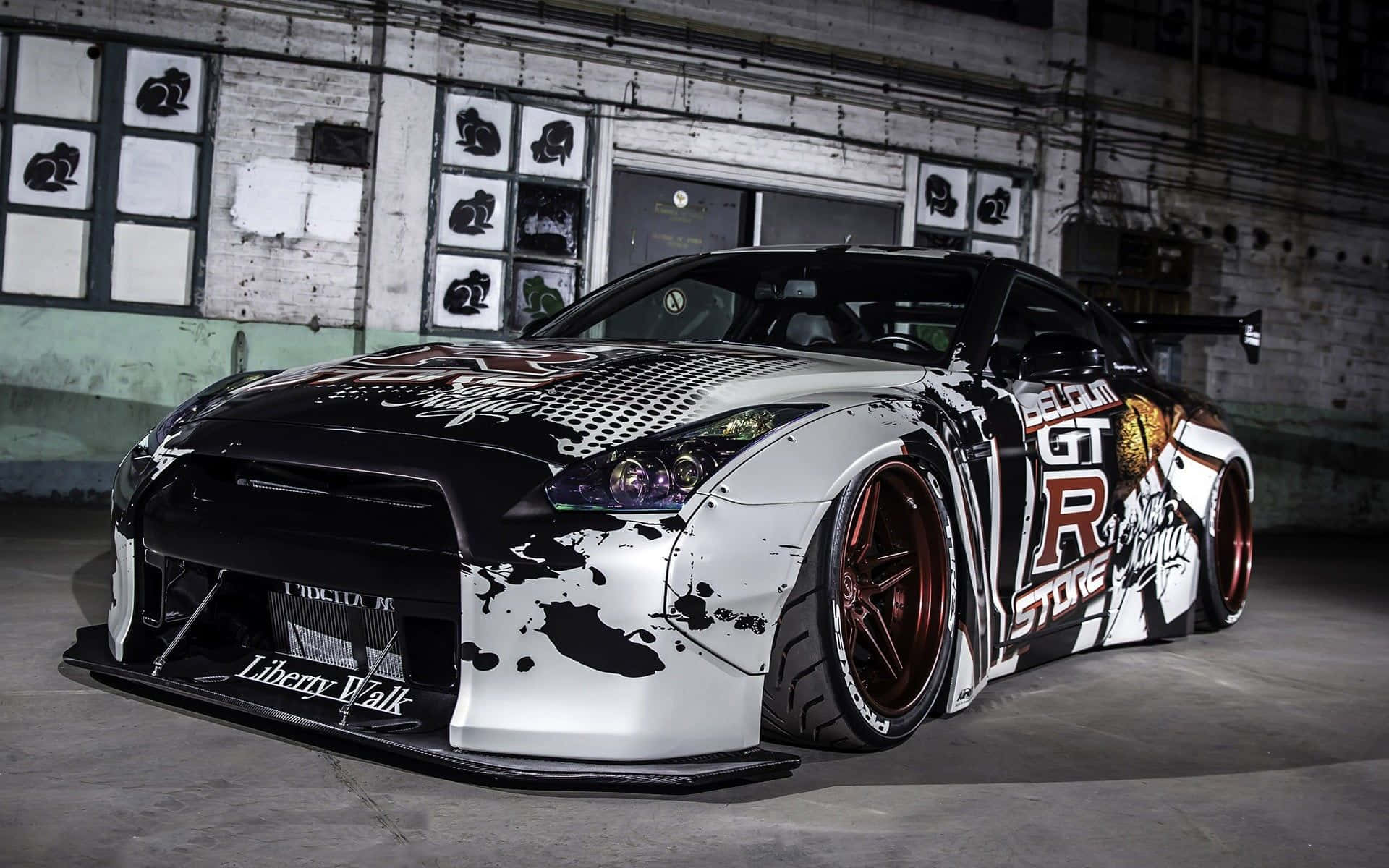 自訂黑白色JDM日產GT-R，紅色輪圈，在混凝土車庫中。