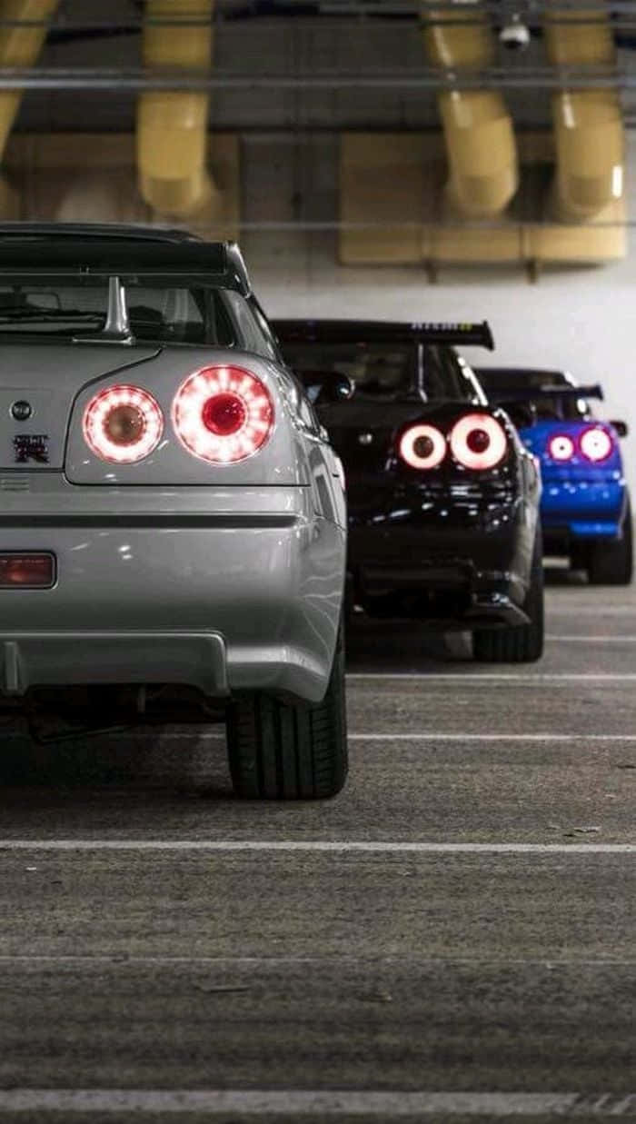三輛改裝跑車帶有發光的尾燈，停放在地下停車場。