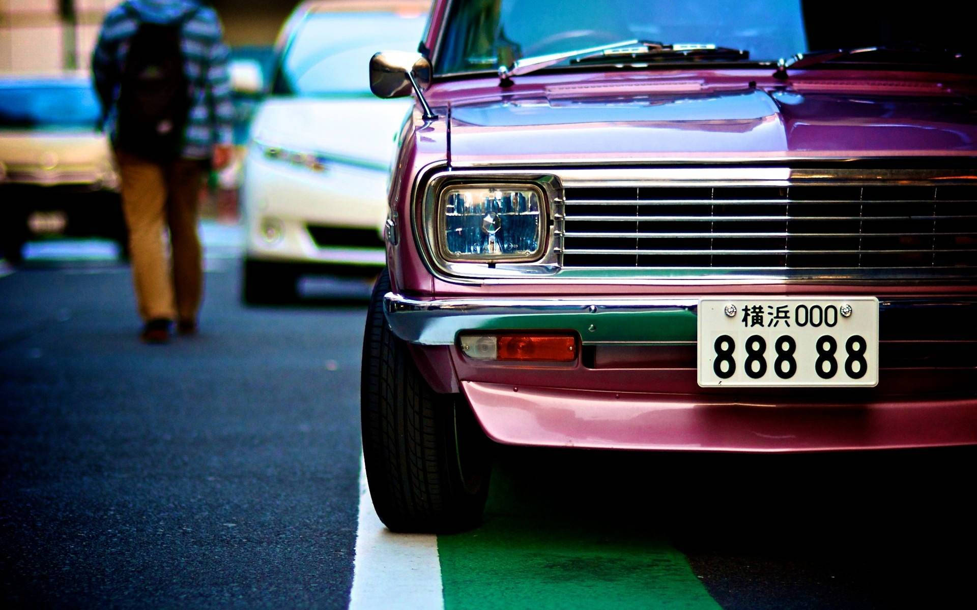 紫色復古車停在城市街道上的特寫，附近有一個人走過。