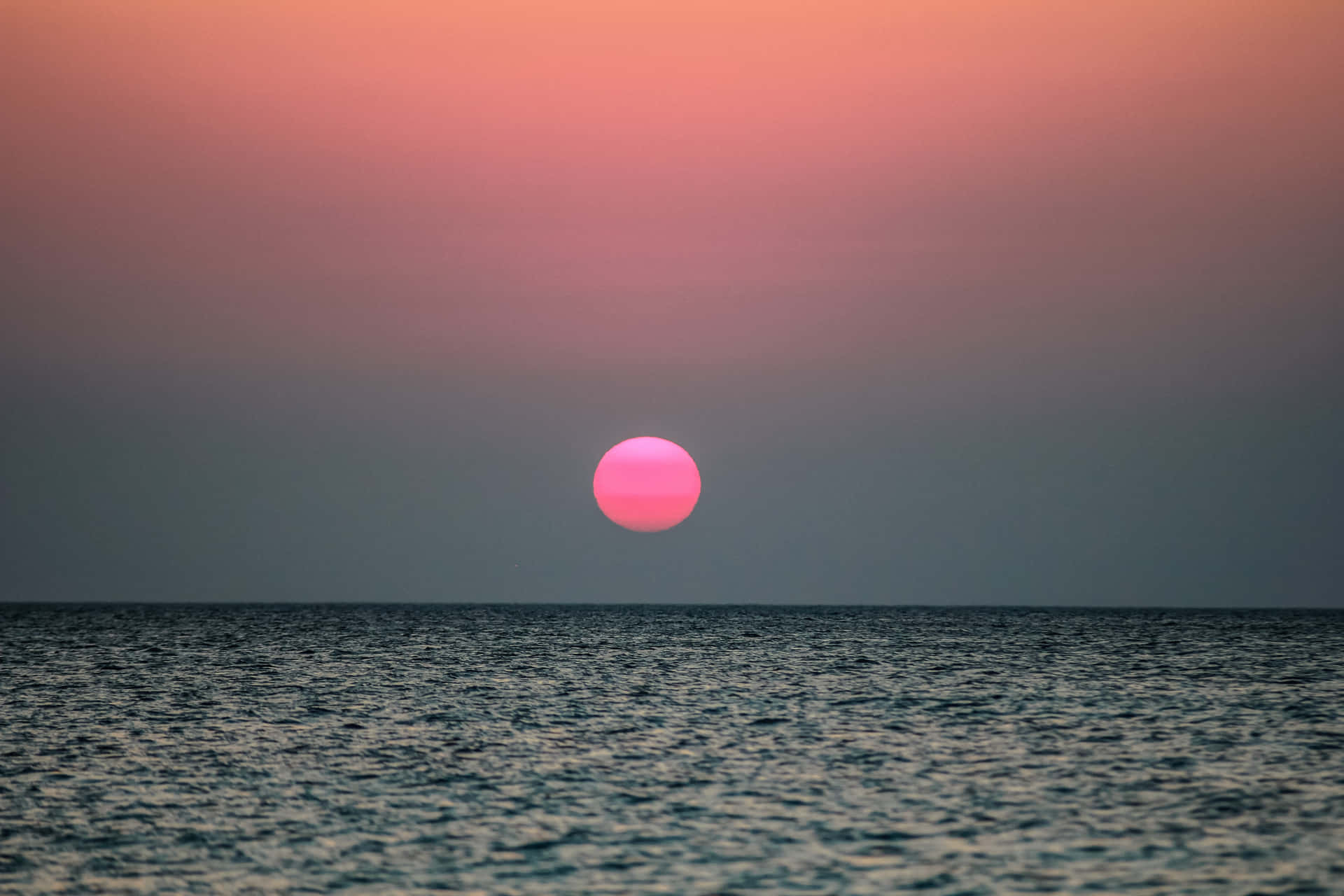 粉紅色夕陽落在平靜的海面上