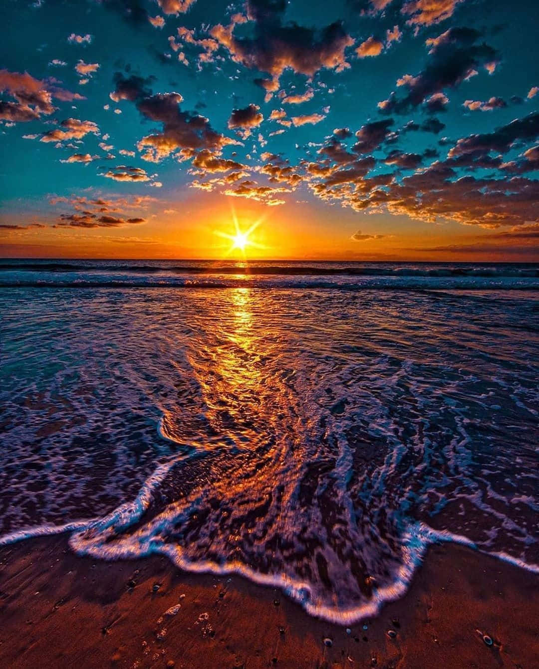 海洋上的日落，海浪沖刷到沙灘上