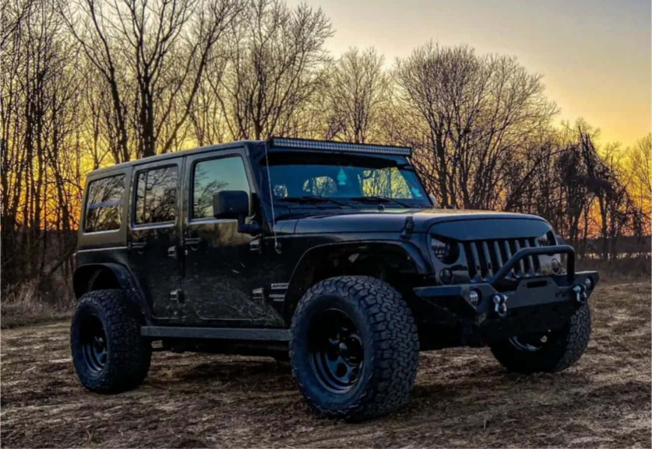 日落時分停泊在樹林中的黑色Jeep 壁紙