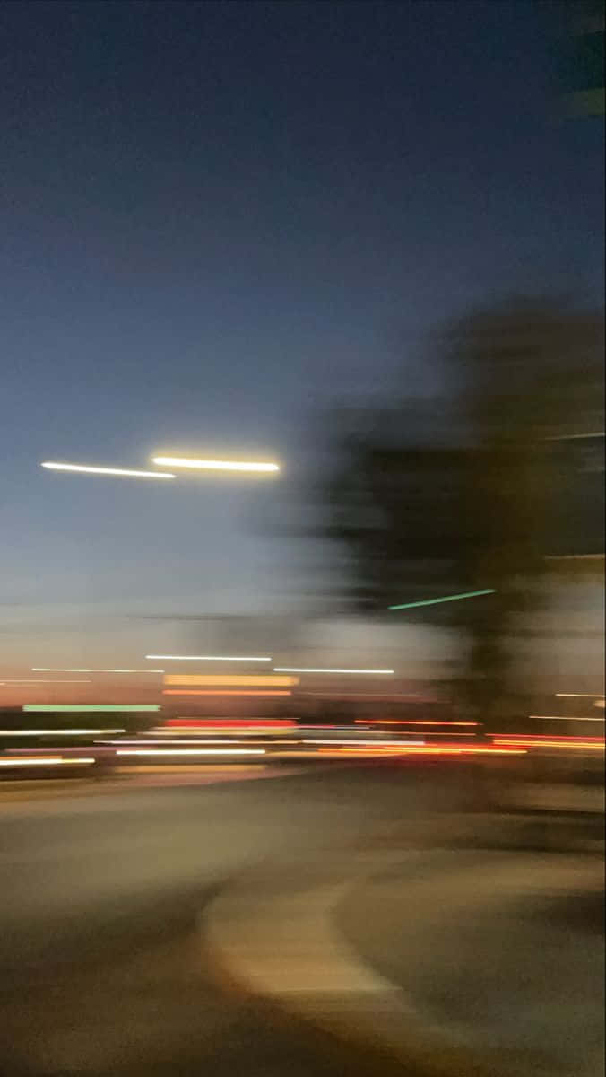 夜晚街道，有來往車輛造成的模糊動態燈光。