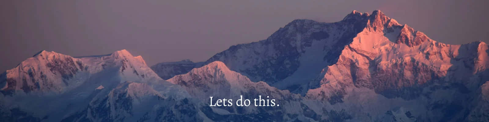 被粉紅色和紫色日出光線沐浴的雪山山脈，帶有文字 Lets do this。