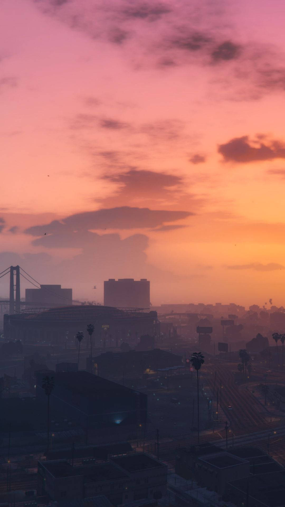 Gta 桌布 壁紙 — 日落時分的城市景觀，溫暖的橙色和粉紅色雲彩籠罩在剪影建築物和棕櫚樹之上。