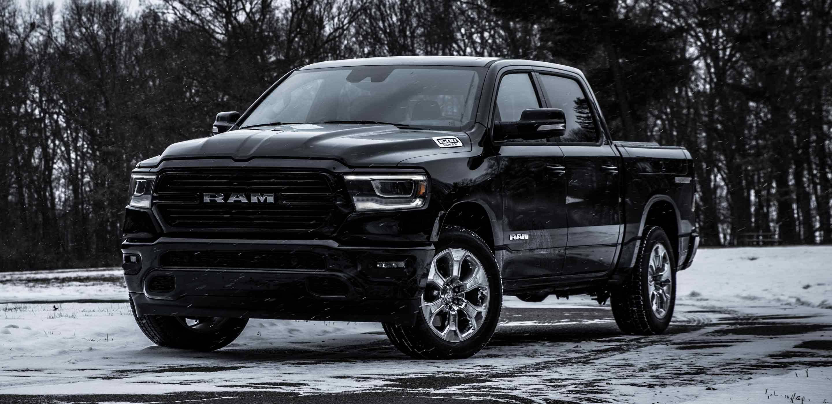 日落時分的黑色 RAM 卡車 壁紙 — 一架型格黑色Ram pickup貨車停泊在積雪的森林道路上，天空是暗淡的冬日色調。