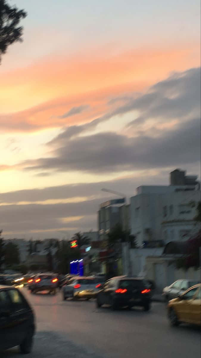 汽車在黃昏時分沿著城市街道行駛，天空色彩繽紛