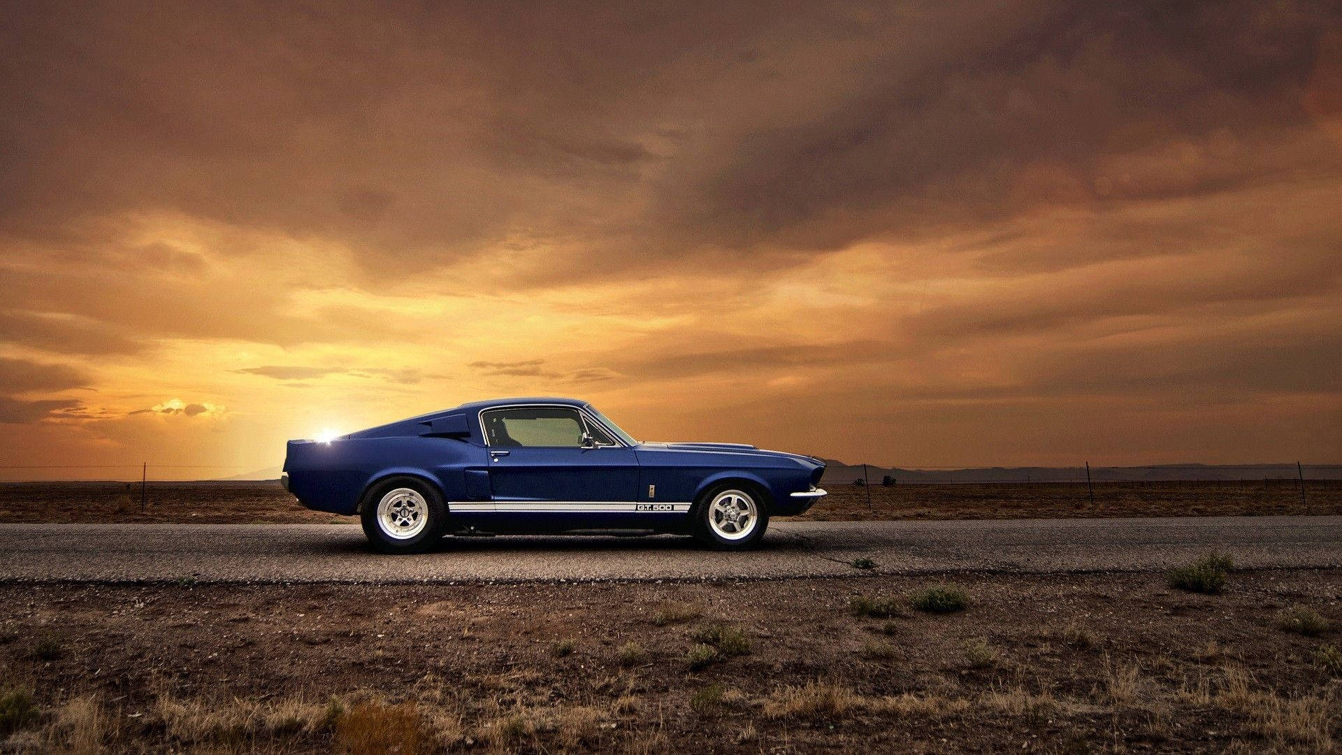經典藍色 Shelby Mustang 在日落時分停在沙漠公路上。
