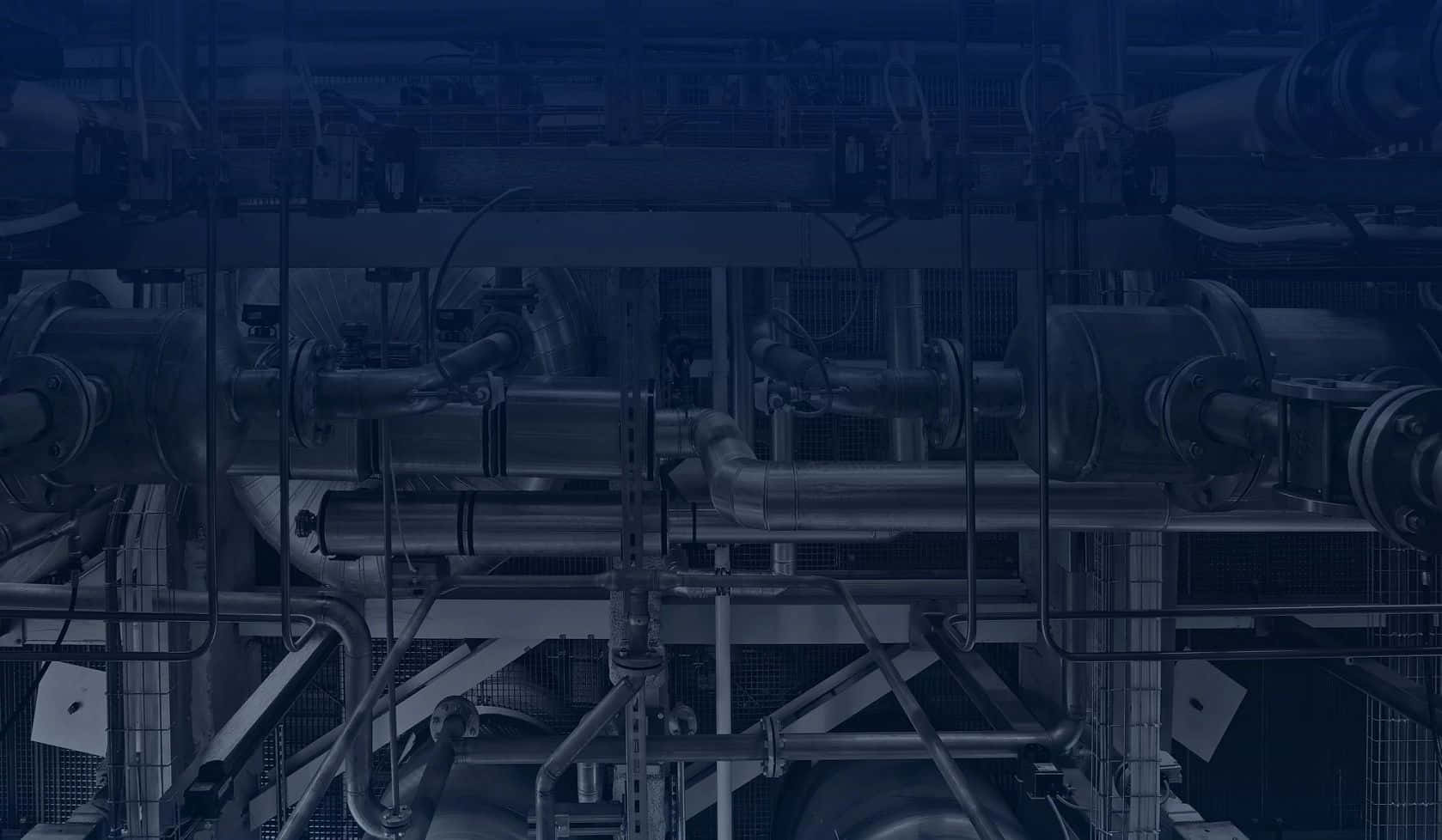 光線昏暗的工廠環境中的工業管道和機械。