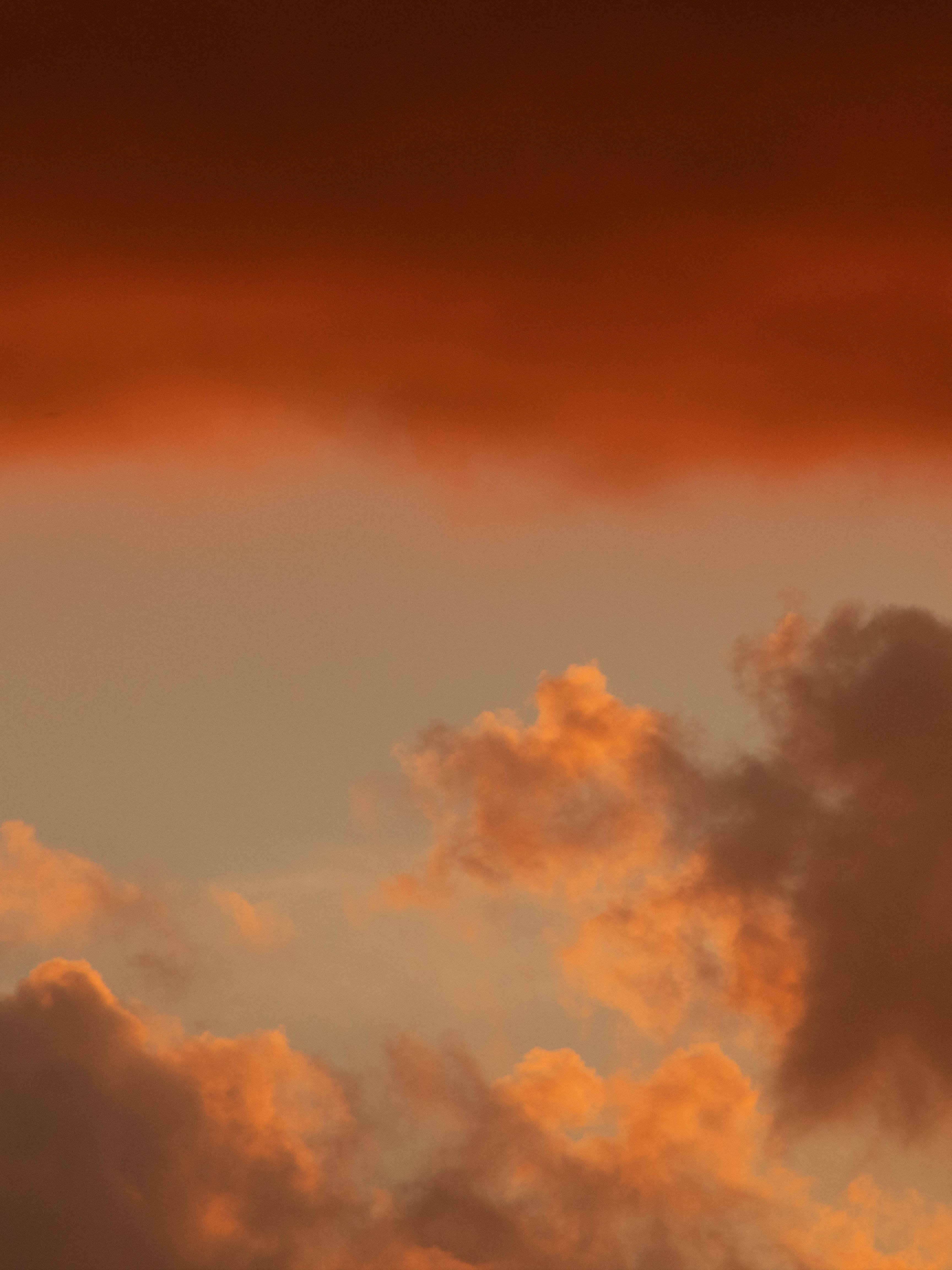 日落時的美麗天空 壁紙 — 戲劇性的雲彩在日落時分，在暮色天空中散發出火橙色和深紅色的光芒。