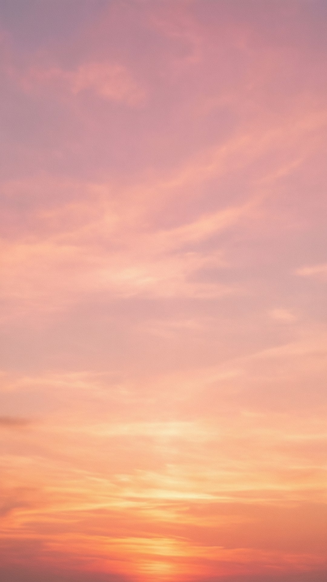 日落粉紅光暈 壁紙 — 太陽在地平線落下時，天空被塗上柔和的粉紅色和橙色調，一片寧靜。