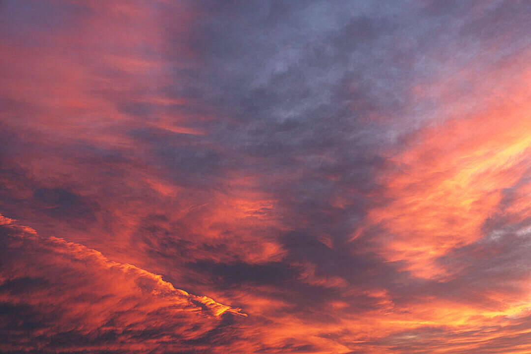 壯麗的日落天空，帶有火橙色和深紫色的雲彩。
