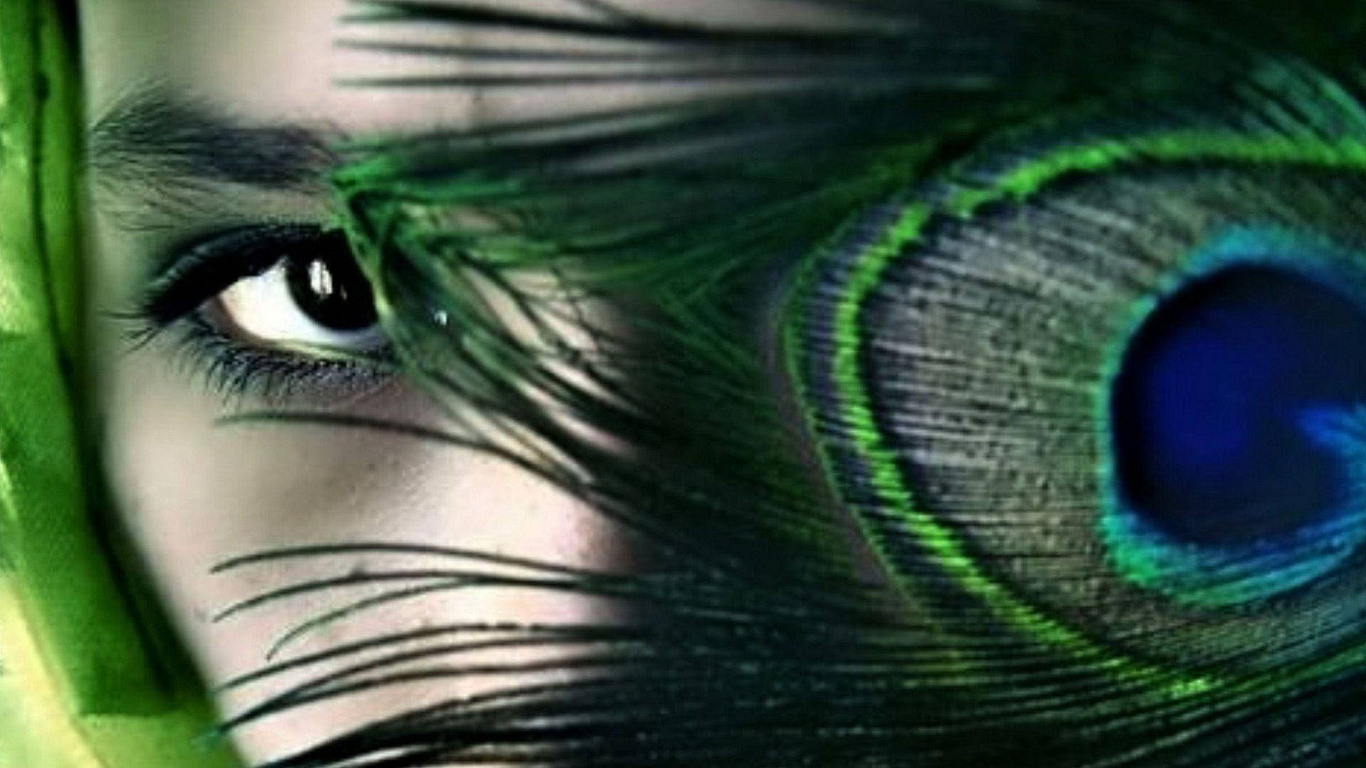 人類眼睛部分隱藏喺帶有虹彩藍色同綠色調嘅孔雀羽毛後面。