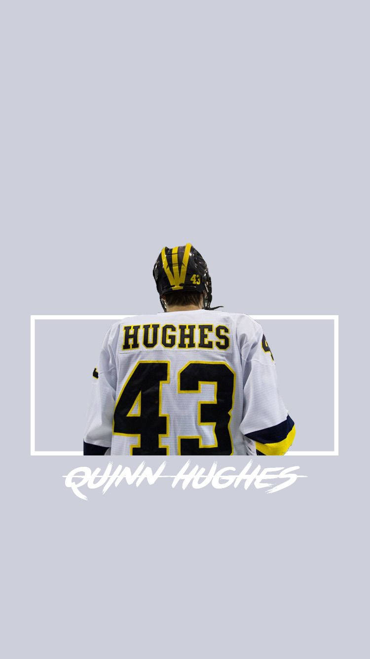 冰球運動員 Quinn Hughes 身穿白色球衣，號碼 43，背對鏡頭。