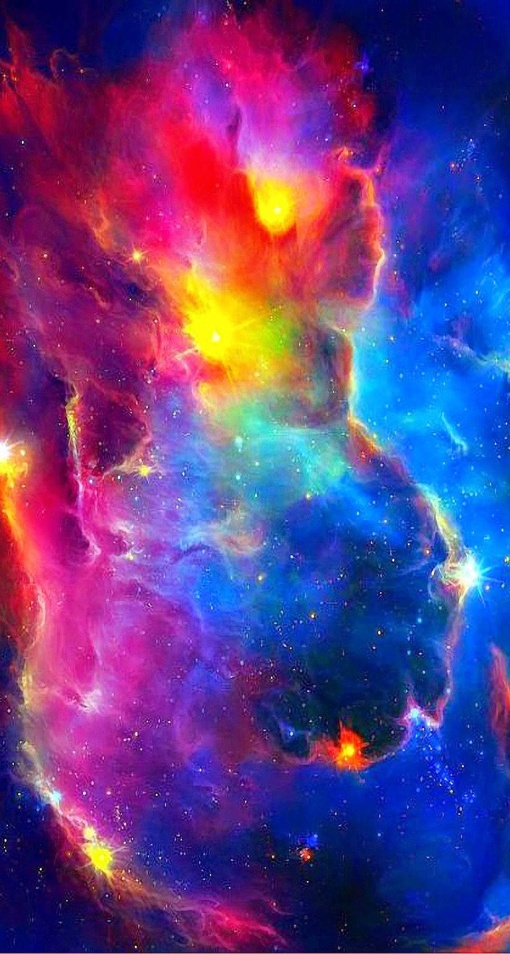 明亮多彩的 iPhone 星空壁紙 壁紙 — 充滿活力的宇宙星雲在粉紅、藍色和黃色的電光色調中旋轉，映襯著繁星點點的虛空。