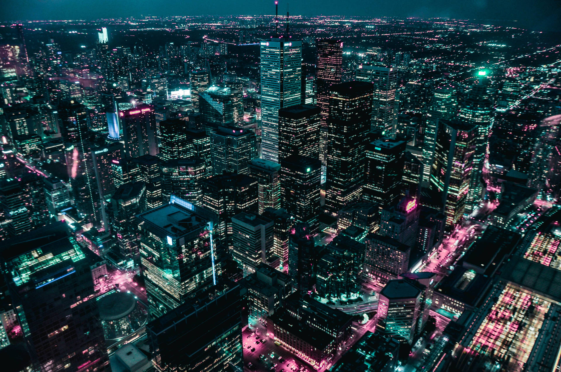 充滿活力的城市夜景鳥瞰圖，有閃爍的摩天大樓和霓虹燈。