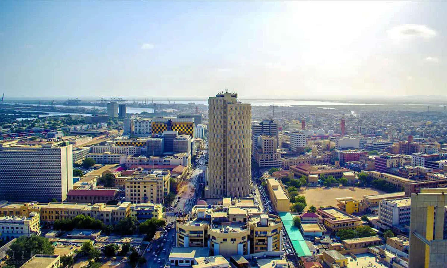 Pakistan 桌布 壁紙 — 明亮日光下，遠方有突出高樓同港口嘅繁忙城市景觀鳥瞰圖。