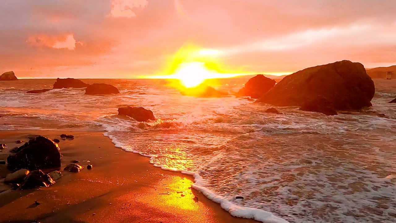 夕陽映照岩石海灘，海浪拍打，金色光線反射在濕沙上。