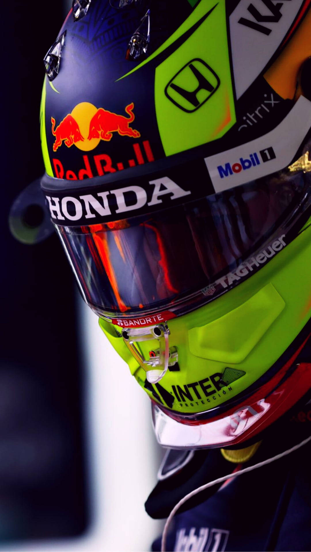 sergio perez 桌布 壁紙 — 明亮燈光下，帶有Red Bull Honda標誌和贊助商貼紙的鮮豔賽車頭盔特寫。