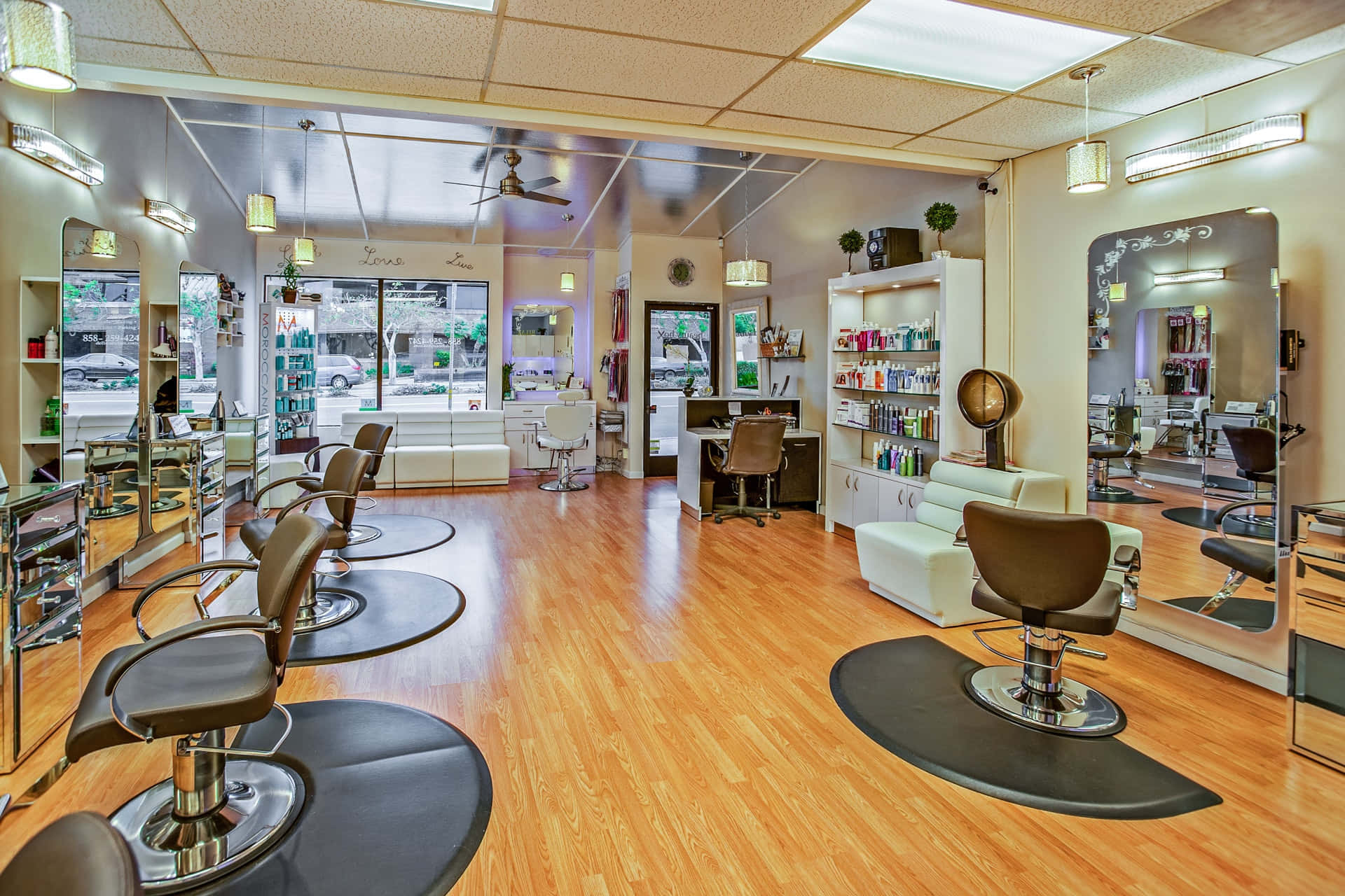 Hair Salon 桌布 壁紙 — 明亮現代髮廊，配有木地板、鏡子、造型椅和髮品貨架。