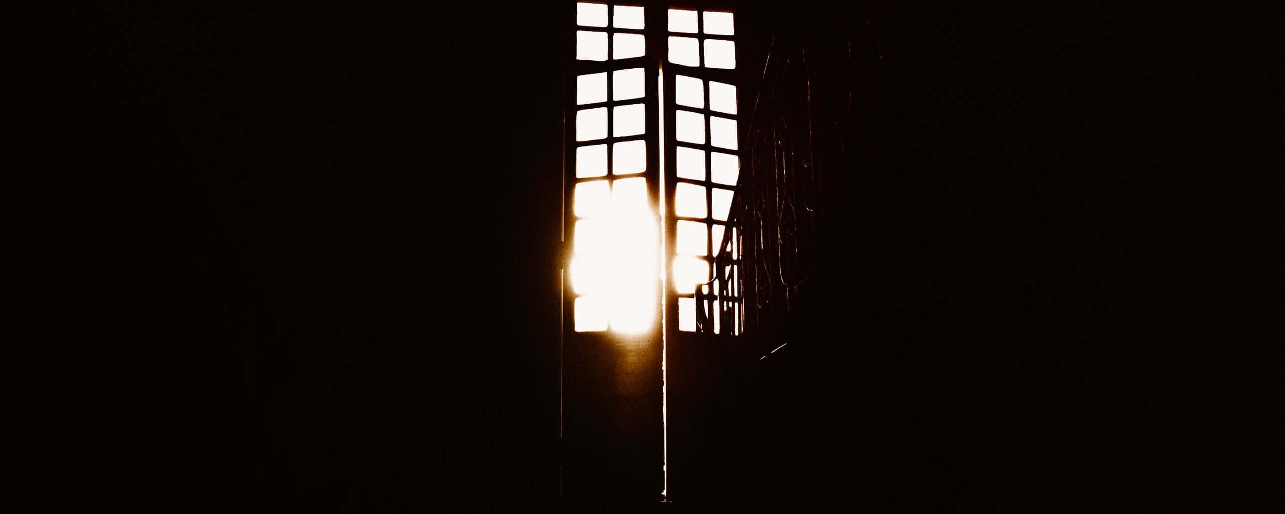 Dark Room 桌布 壁紙 — 明亮的太陽穿過高而窄的窗戶照射進來，在黑暗的室內投射出金色的光芒。