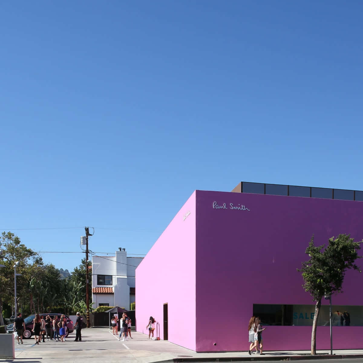 Pink Wall 桌布 壁紙 — 明亮的粉紅色 Paul Smith 商店建築，在清澈的藍天下，行人走在行人路上。