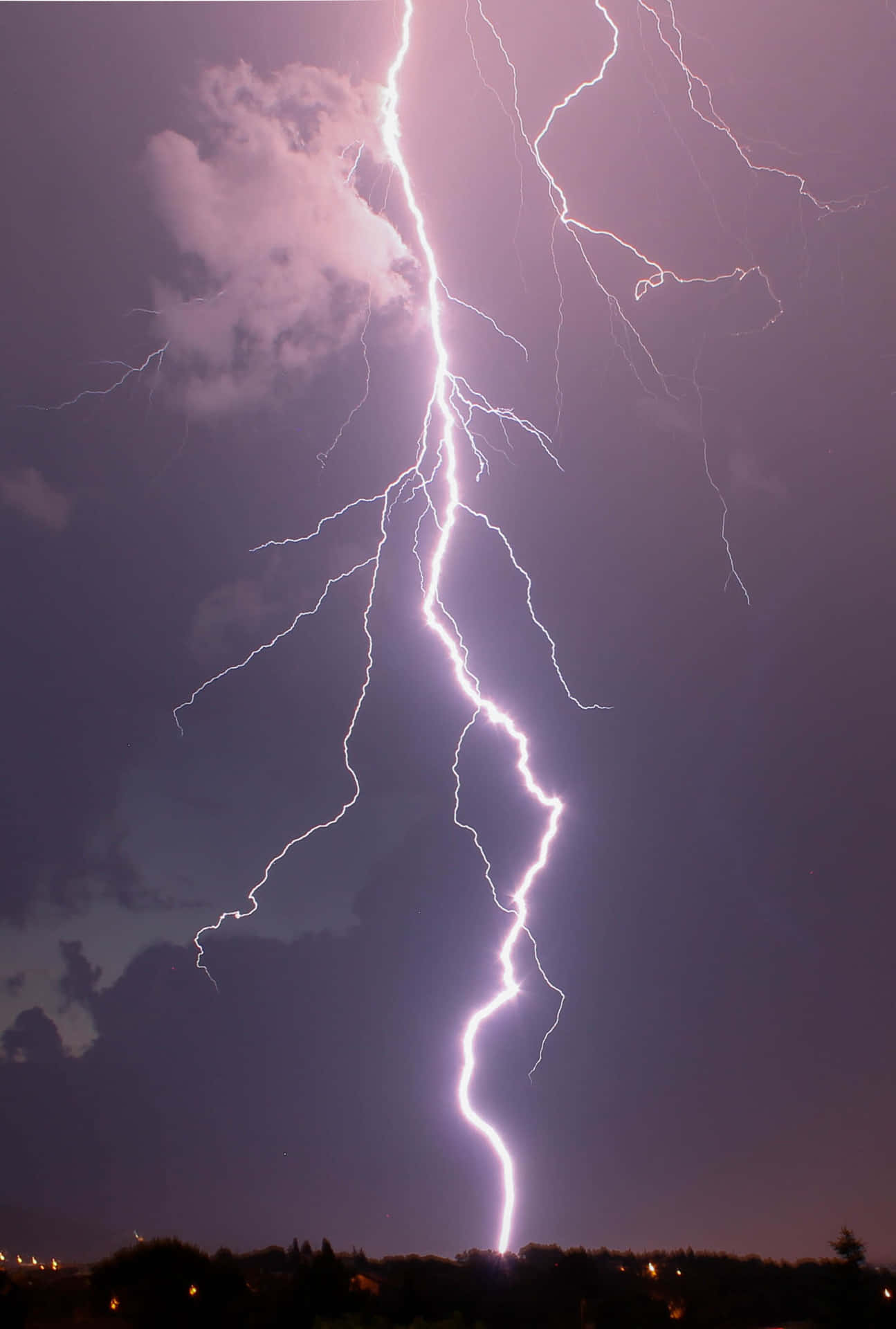 強大的閃電照亮了黑暗景觀上方的暴風雨夜空。