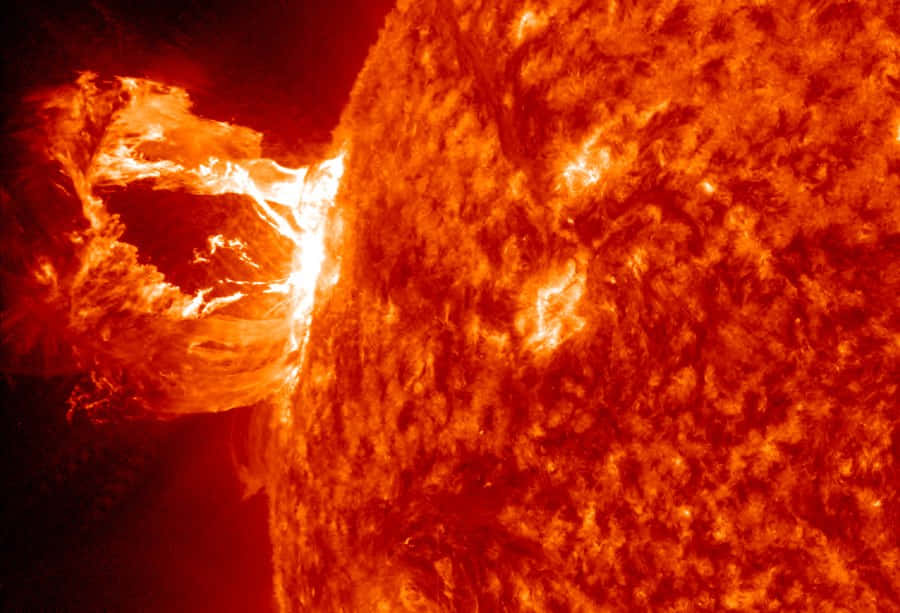 一場巨大的太陽耀斑從太陽表面爆發，呈現熾熱的橙色等離子體。