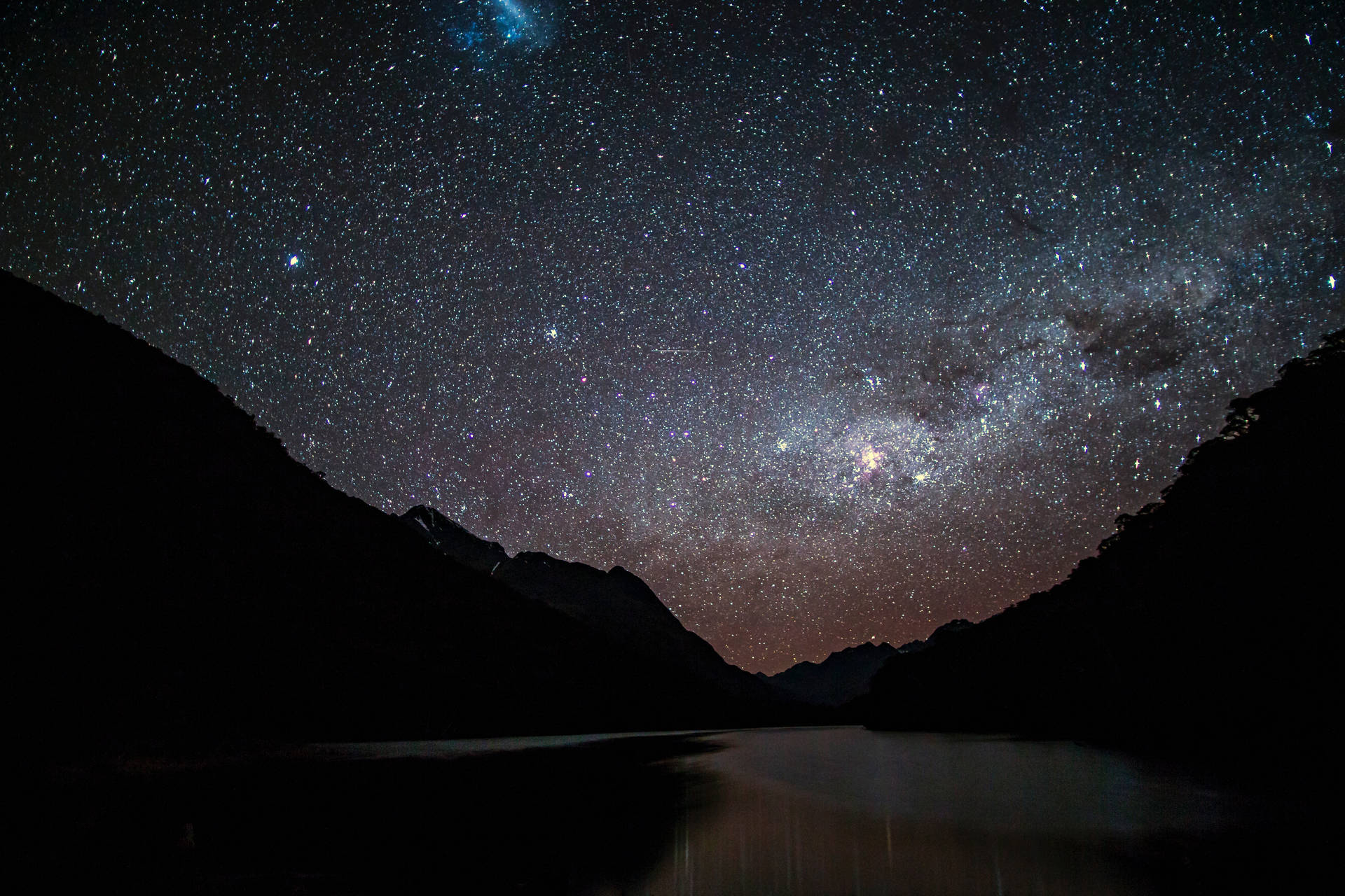 銀河系在夜晚照耀著山間湖泊