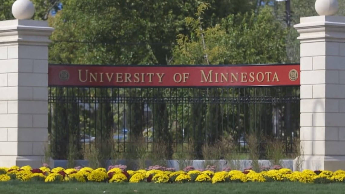 University of Minnesota入口大門，配有黃色花朵和石柱。