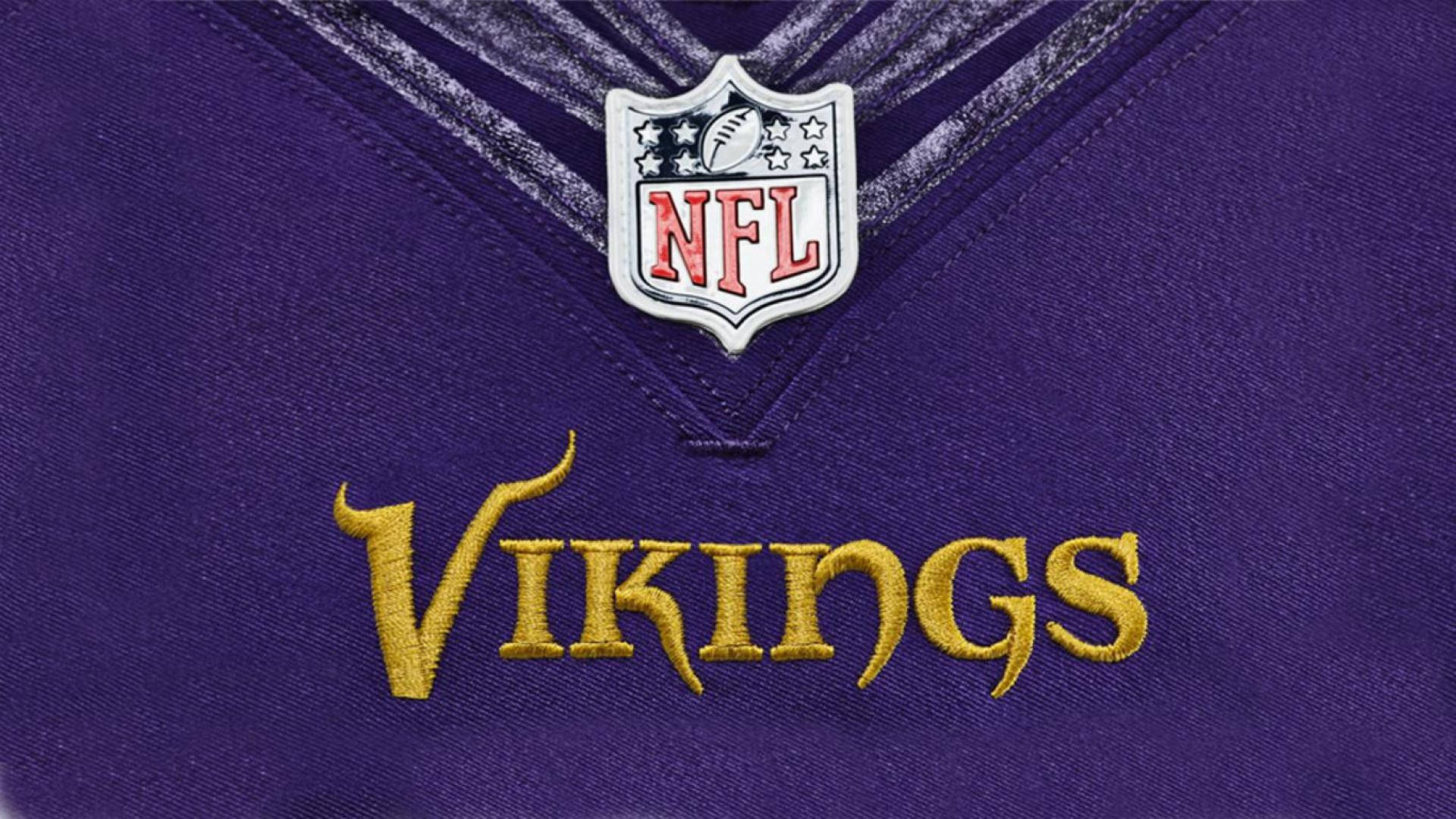紫色維京人隊NFL美式足球球衣特寫，金色字體和隊徽。