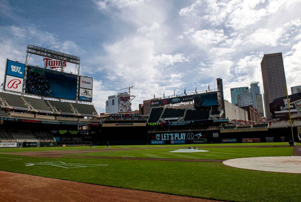 明尼蘇達雙城隊棒球場 壁紙 — 在部分多雲的天空下，Target Field 棒球場的廣闊視野，背景是城市摩天大樓。